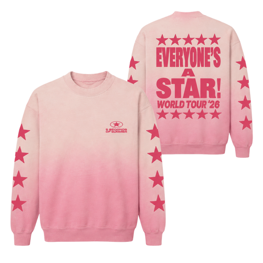A pink crewneck sweatshirt with a vertical gradient fading from light pink at the top to a deeper pink at the bottom. The back of the sweatshirt features a large pink graphic reading 'EVERYONE'S A STAR! WORLD TOUR '26' surrounded by stars, and the sleeves have pink stars printed down the sides.